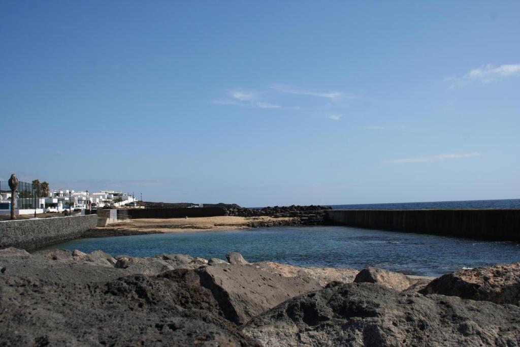 a body of water with rocks in the foreground at MariCel in Teguise