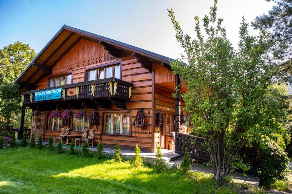 a log cabin with a porch and a balcony at Józefina in Szczyrk