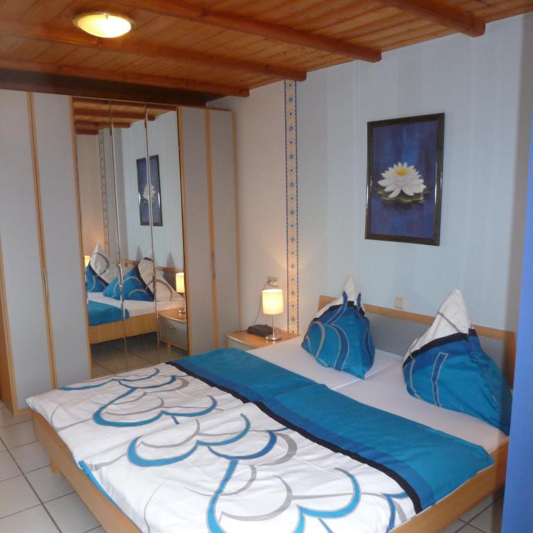 Ferienhäuser Näckel في Gransdorf: غرفة نوم بسرير كبير مع وسائد زرقاء