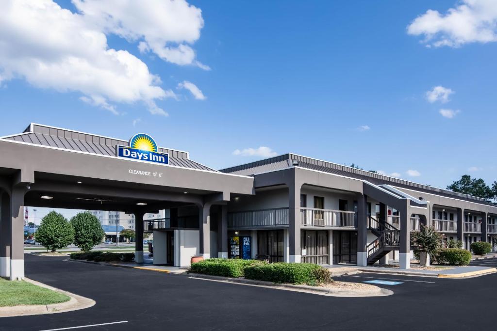 a hotel with a sign on the front of a building at Days Inn by Wyndham Wilson in Wilson