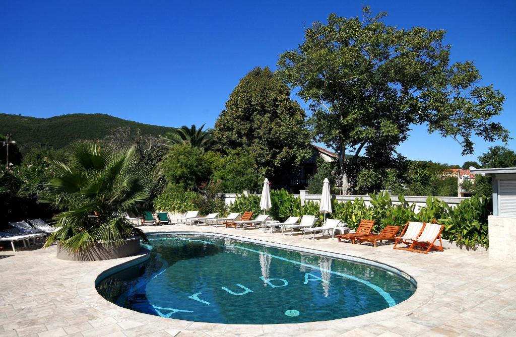 a swimming pool with lounge chairs and a resort at Hotel Aruba in Budva