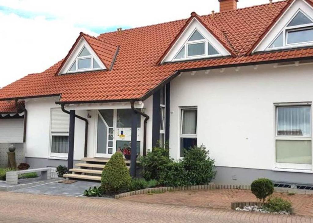 ein weißes Haus mit rotem Dach in der Unterkunft Ferienwohnung Weiß Wachtenburg in Wachenheim an der Weinstraße