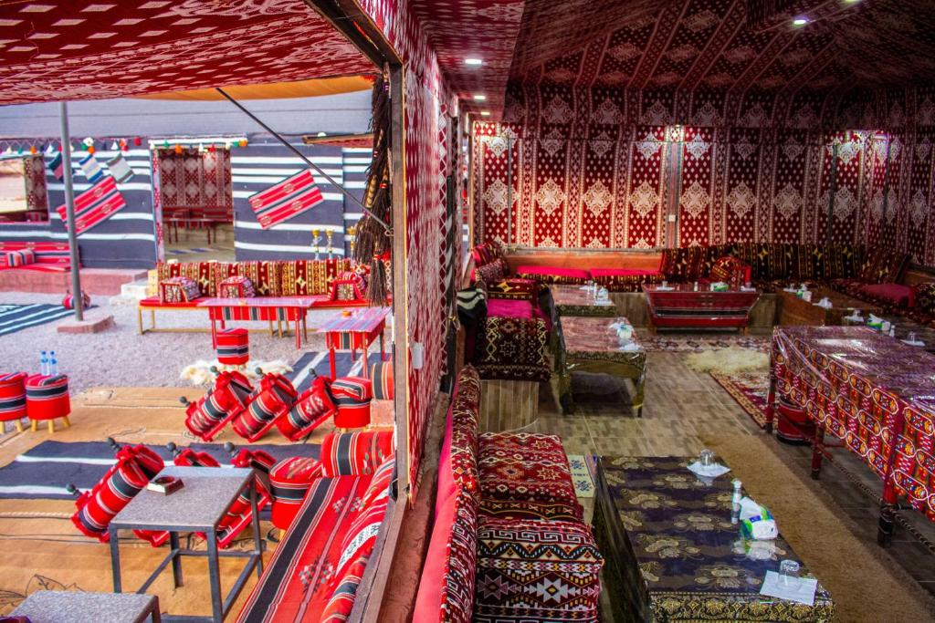 a large room with couches and tables in a room with at Wadi Rum Dream Camp in Wadi Rum