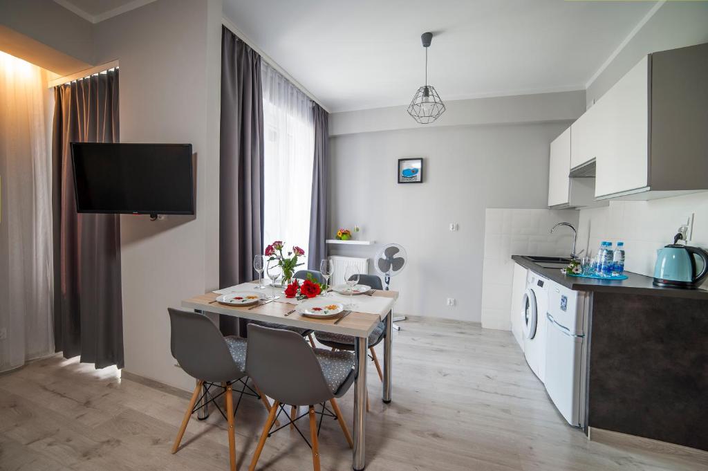 a kitchen and dining room with a table and chairs at STOP Apartment in Suwałki