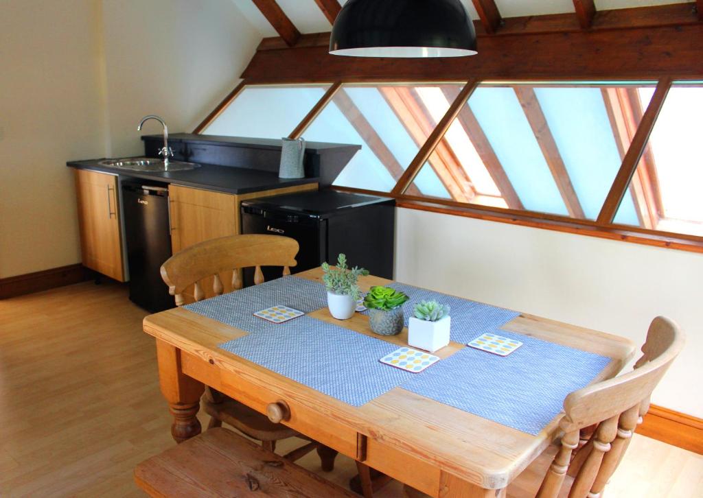 Hooters Apartment EV Point في ويدبريدج: مطبخ مع طاولة خشبية عليها نباتات
