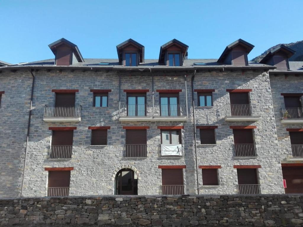 un grand bâtiment en briques avec des fenêtres latérales dans l'établissement Apartamento Punta Gábalo, à Broto