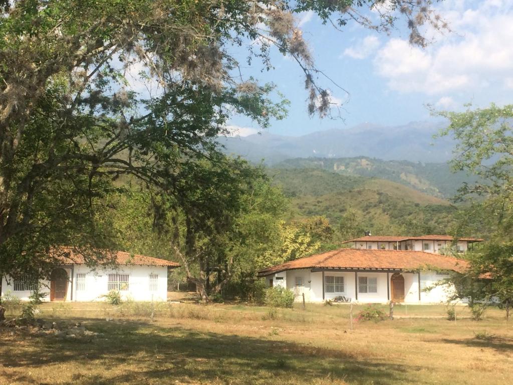 a house in a field with mountains in the background at Finca Bellavista in Ginebra