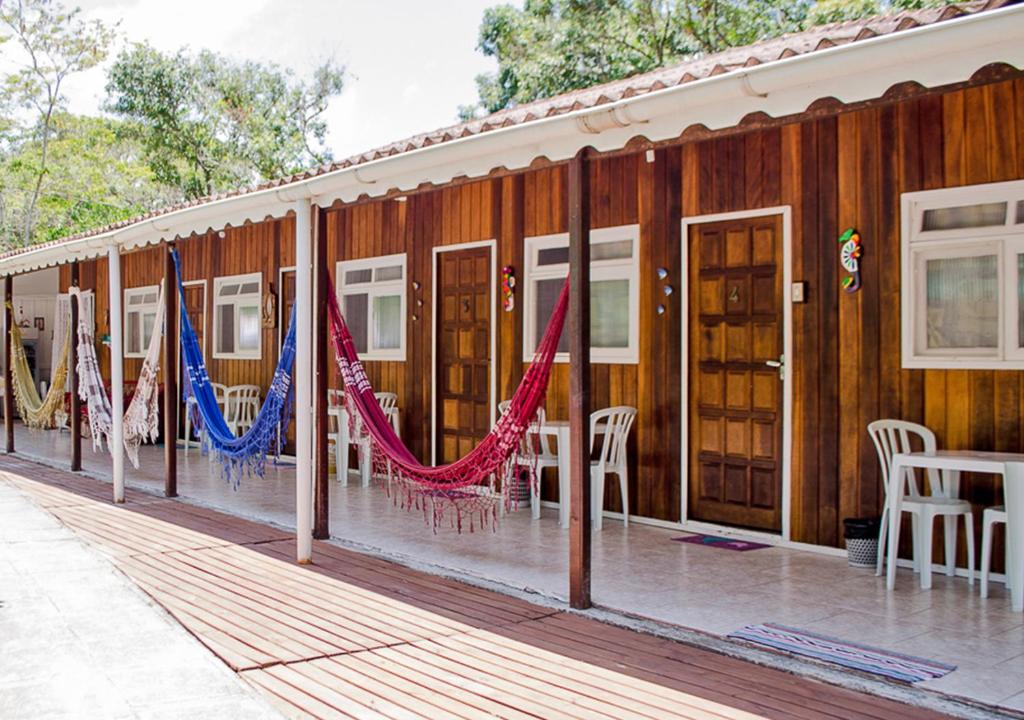 un edificio con banderas, mesas y sillas en Pousada Renascer, en Ilha do Mel