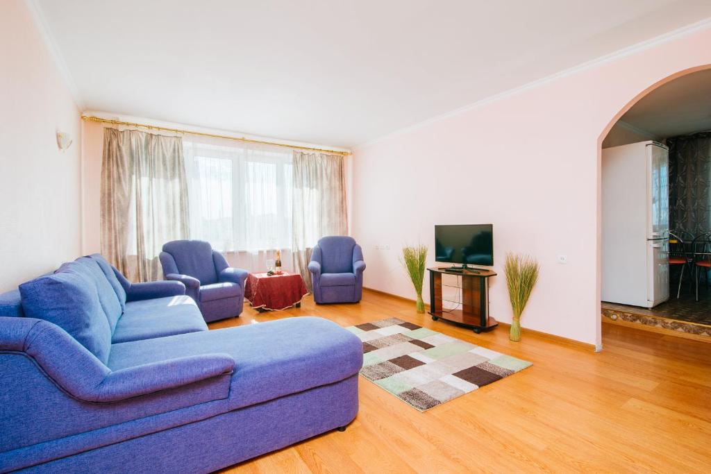 a living room with a blue couch and two chairs at Apartment on Nemiga in Minsk
