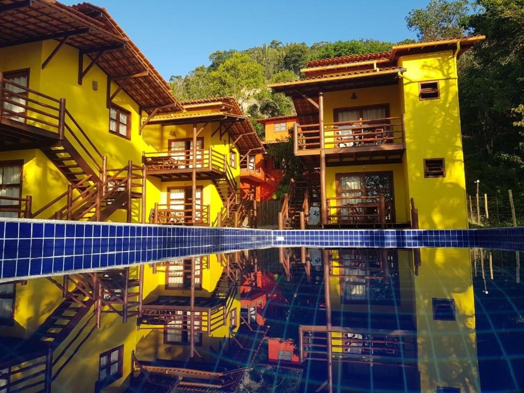 a building with a pool in front of it at Sina Residencial in Morro de São Paulo