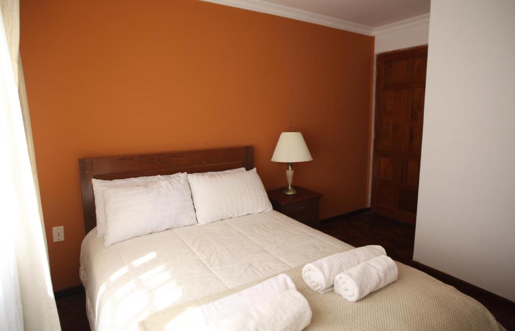 a bedroom with a bed with two towels on it at Casa Los Jazmines in Sucre