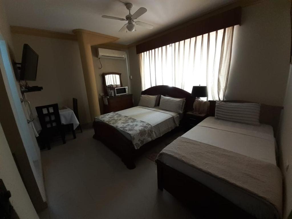 Habitación de hotel con 2 camas y ventana en Casa Serena, en Guayaquil