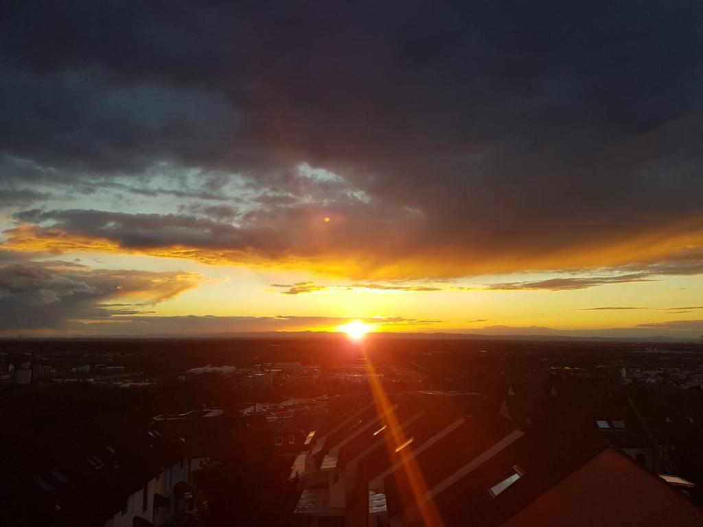 a sunset in a city with the sun setting at Dachgeschoss in einem Reihenhaus (mit gemeinschaftlichen Räumen) in Heidelberg