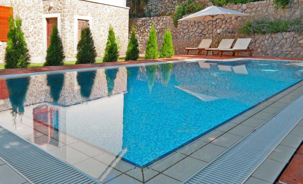 - une piscine d'eau bleue dans une maison dans l'établissement Vila Harmonia, à Veprinac