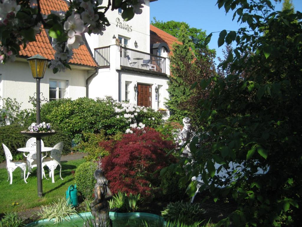 a garden in front of a white building at Nya Pallas Hotel in Falkenberg