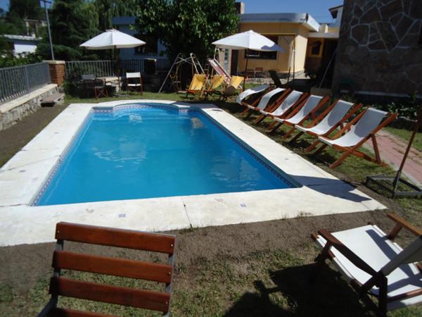 a pool with a bunch of chairs and a bunch at Hotel El Nogal in La Falda