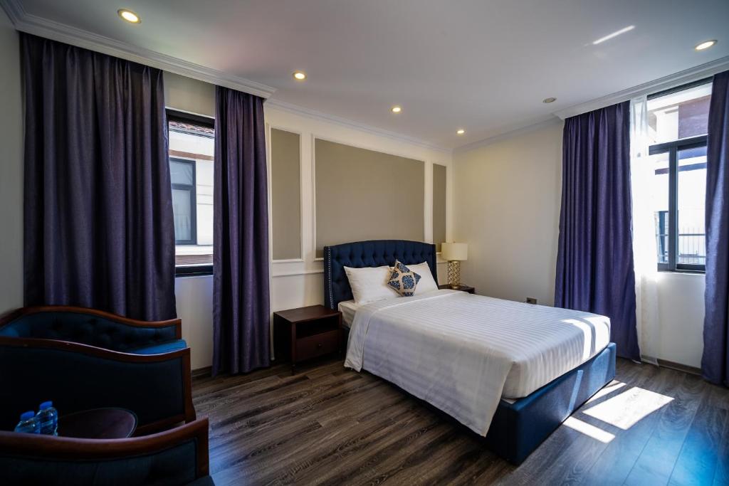 une chambre d'hôtel avec un lit et deux fenêtres dans l'établissement IDC White House Ha Long FLC Golf & Resort, à Hạ Long