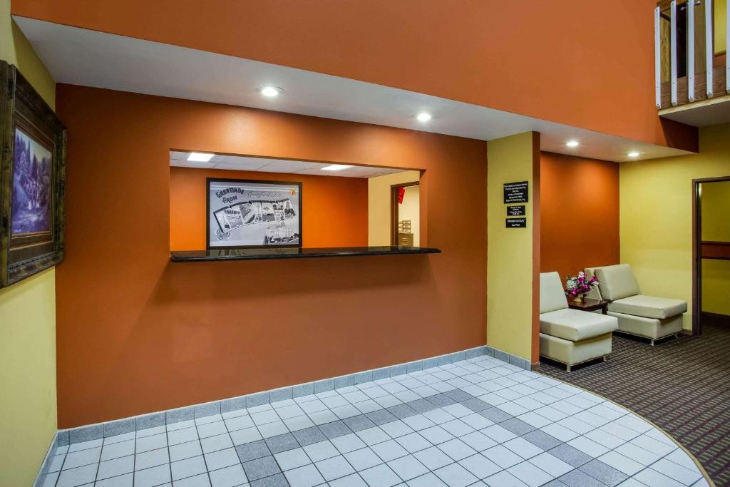 una sala de espera con paredes de color naranja y un espejo en Super 8 by Wyndham Crawfordsville en Crawfordsville