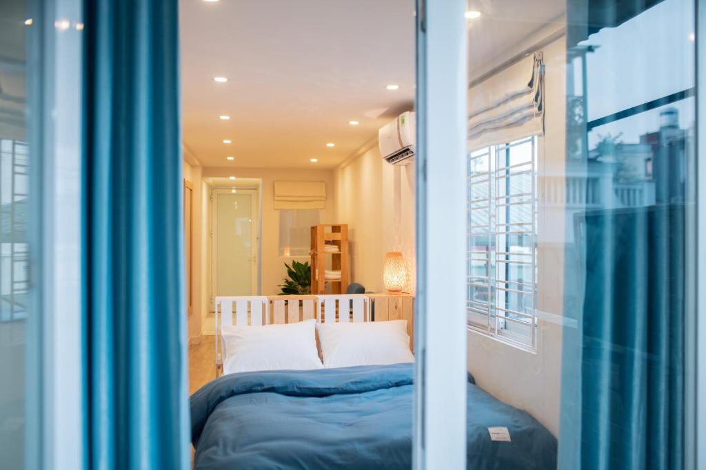ハノイにあるGraffiti Hotelのベッドと窓のある寝室