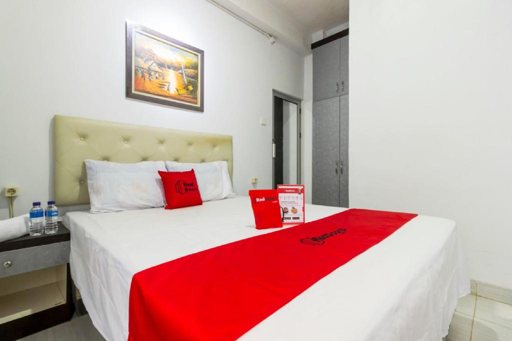 een slaapkamer met een groot bed met een rode deken erop bij Reddoorz near Gajah Mada Plaza 2 in Jakarta