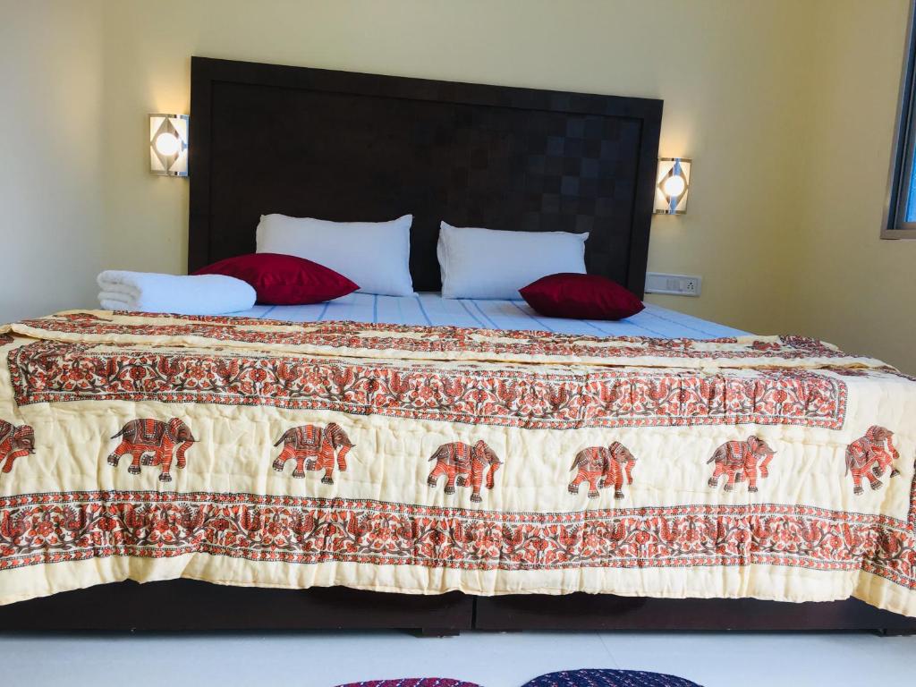 1 dormitorio con 1 cama grande con almohadas rojas en The Highvill Home Stay en Khajurāho