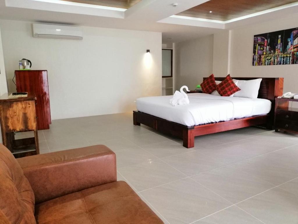 Nirvana Resort Puerto Galera في بويرتو غاليرا: غرفة معيشة مع سرير وأريكة