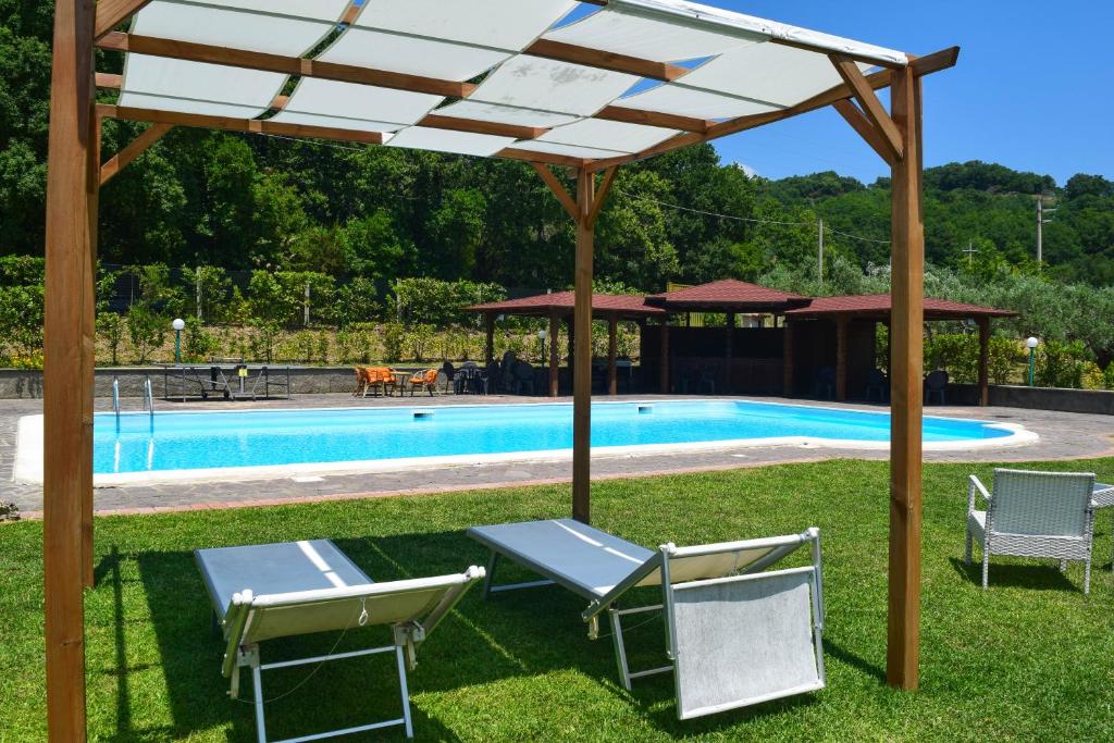 pergola z krzesłami i basenem w obiekcie Agrilao w mieście Scalea