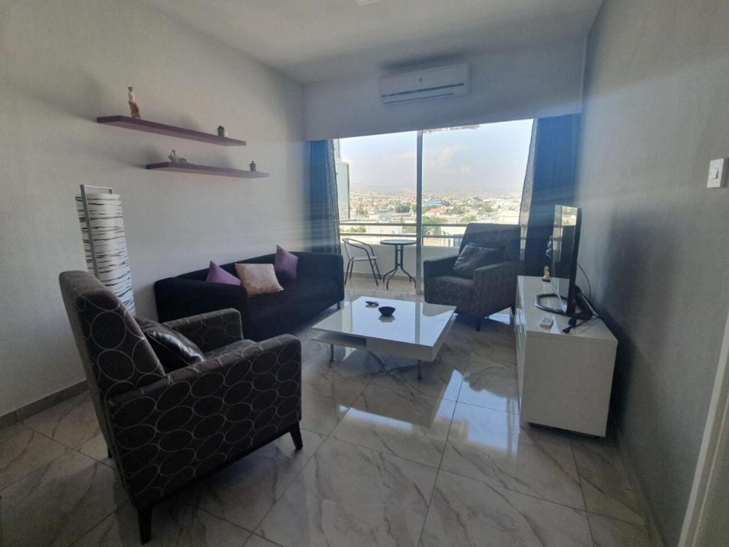 un soggiorno con divano, sedie e tavolo di Great views apartment. a Limassol