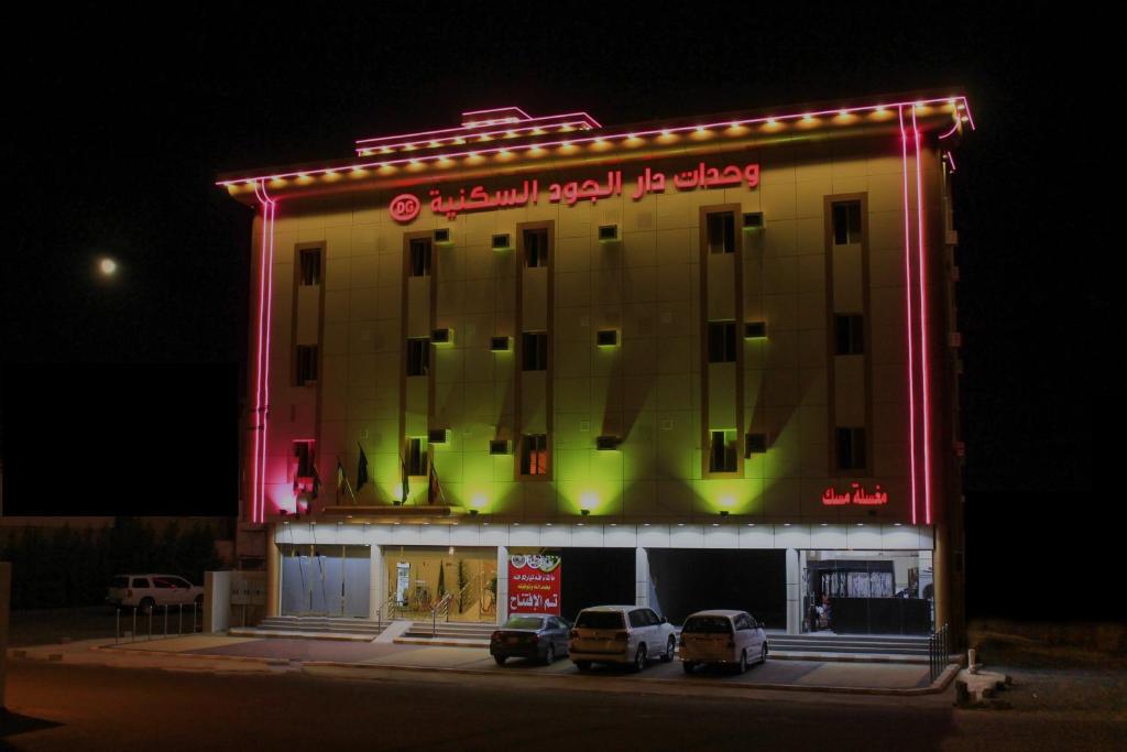 وحدات دار الجود الفندقية في قلعة بيشة: مبنى فيه سيارات تقف امامه ليلا