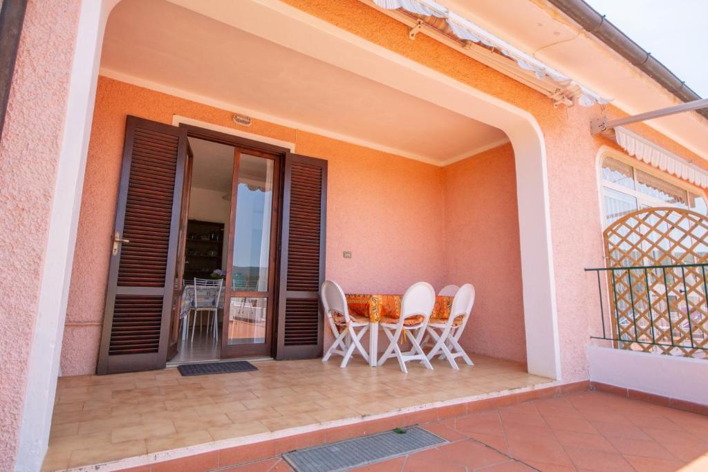 patio z krzesłami i stołem na balkonie w obiekcie Le Saline w mieście Portoferraio