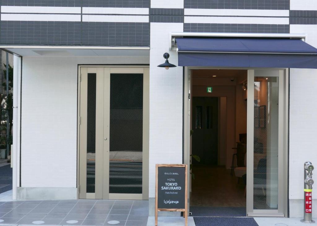 a building with a sign in front of a door at Tokyo Sakurako Hatchobori in Tokyo