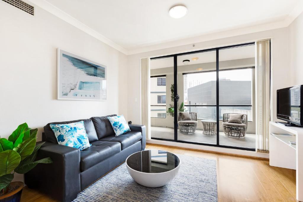 - un salon avec un canapé et une télévision dans l'établissement 1 bdrm Surry Hills - Super central location -1012 ELZ, à Sydney