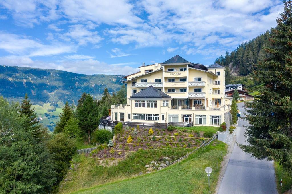 ein großes weißes Haus am Straßenrand in der Unterkunft Wellness Aparthotel Panorama Alpin - Ferienwohnungen Jerzens im Pitztal in Jerzens