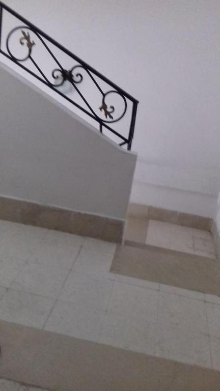 un banco de metal sentado en la parte superior de una escalera en Dar el Baraka en Bizerte