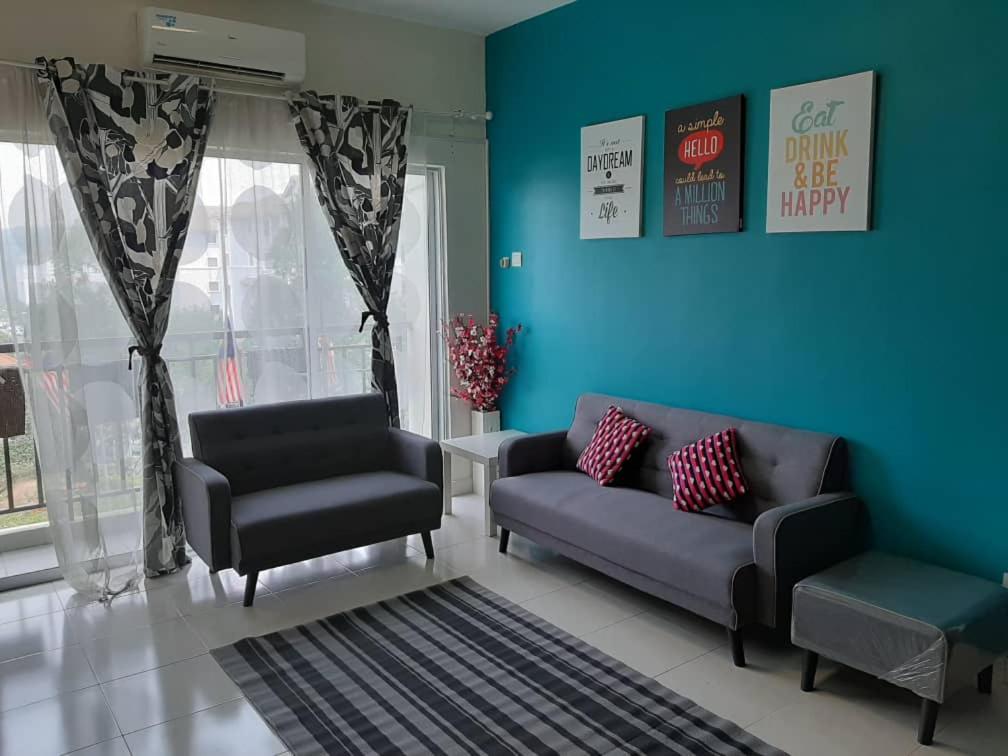 uma sala de estar com dois sofás e uma parede azul em Homestay Puncak Alam Residensi Allamanda em Bandar Puncak Alam