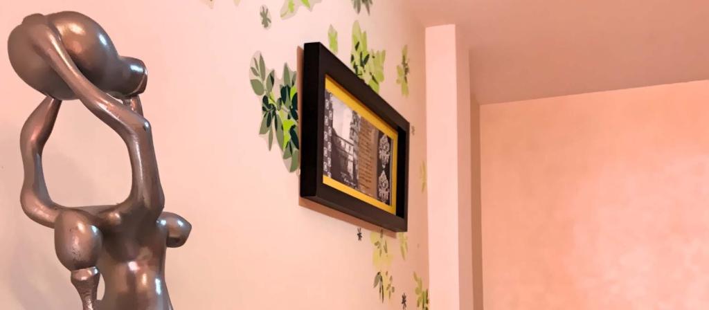 statua psa na ścianie obok obrazu w obiekcie VENUS DE BAEZA SUITE w mieście Baeza
