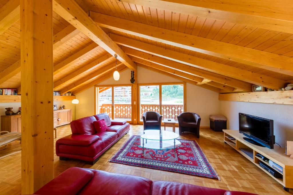 ナンダにあるChalet Yokangaの赤いソファとテレビのあるリビングルーム