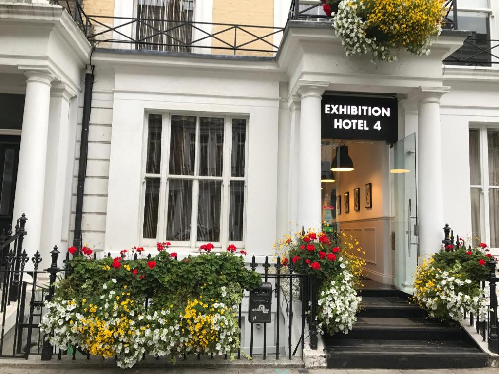 a white house with flowers in front of it at Exhibition Court Hotel 4 in London
