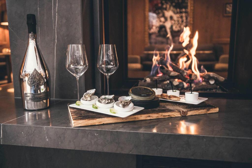 a table with two plates of food and wine glasses at Schlosshotel Ischgl 5-Sterne Superior in Ischgl