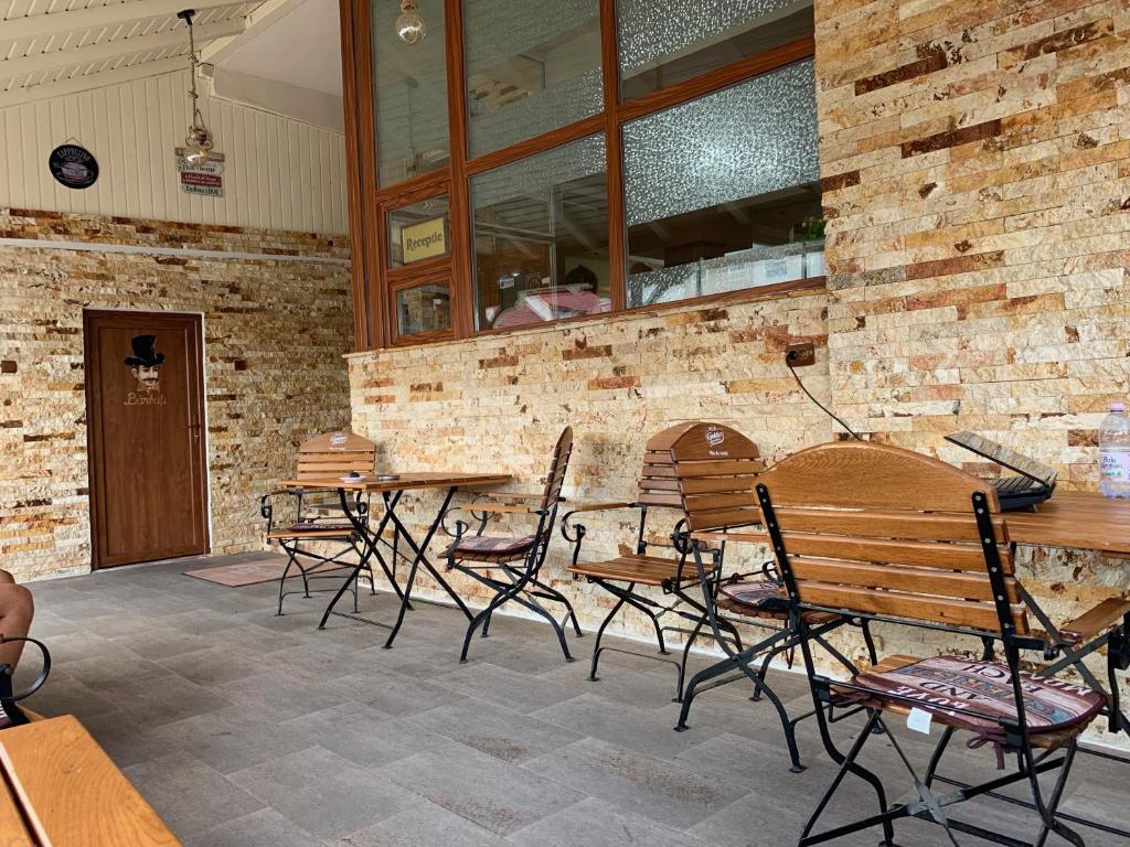 un restaurante con mesas y sillas y una pared de ladrillo en Hotel Monte Carlo, en Piteşti