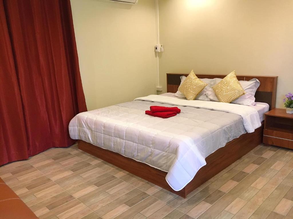 - une chambre dotée d'un lit avec une chemise rouge dans l'établissement นพรัตน์การ์เด้นฮิลล์, à Uthai Thani