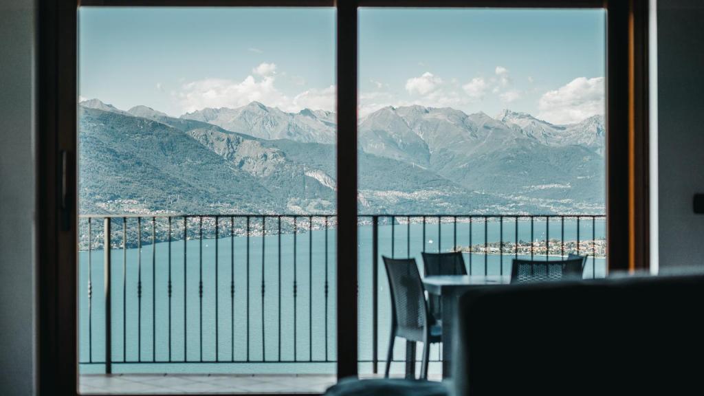 a view of the mountains from a window with a table and chairs at Residence Primavera in Bellano