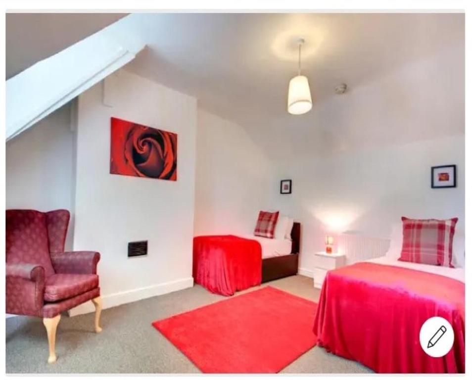 a bedroom with a red bed and a chair at Your Nottingham Vacation, Business Apart, Parking in Nottingham