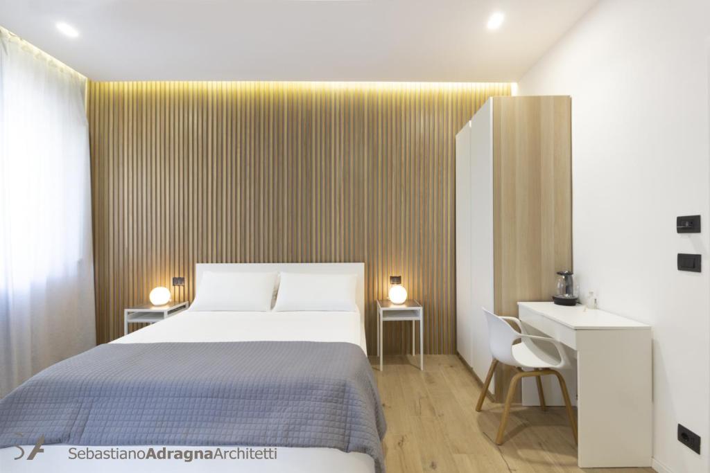 ein Hotelzimmer mit einem Bett, einem Schreibtisch und einem Schreibtisch in der Unterkunft Le Dimore Degli Archi Catania in Catania