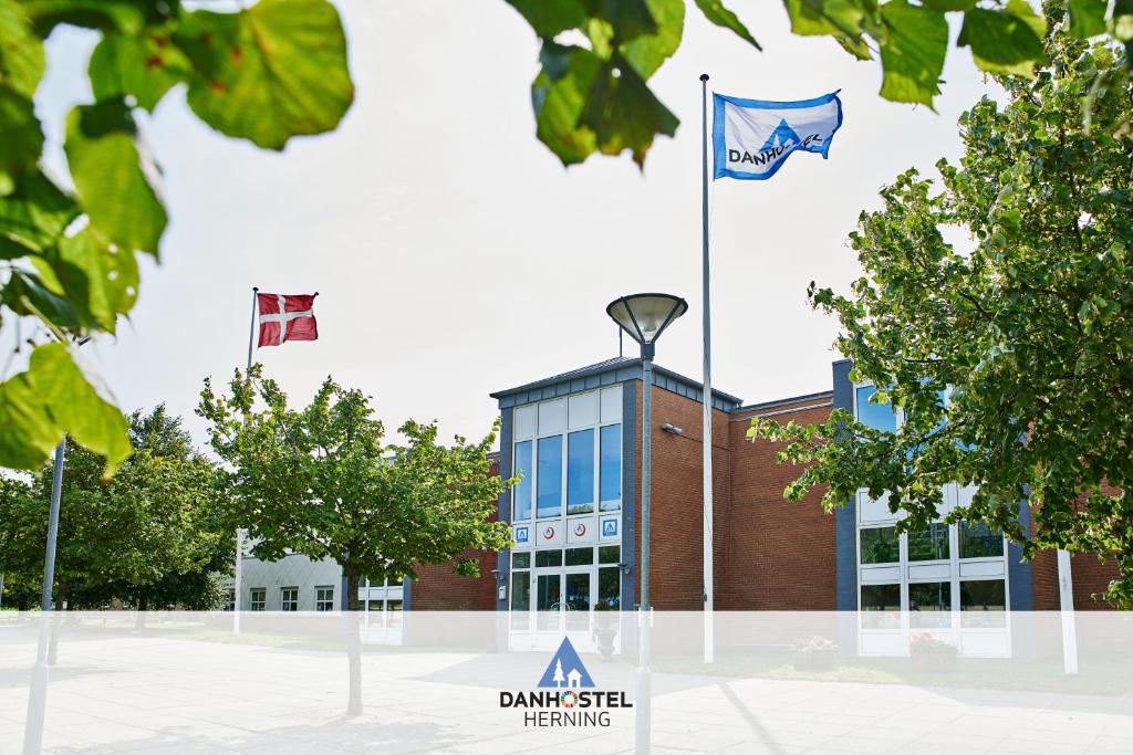 dos banderas volando delante de un edificio en Danhostel Herning en Herning