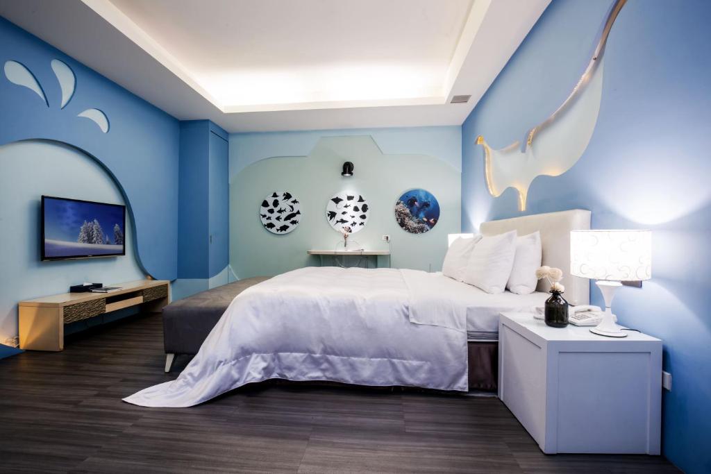 - une chambre avec des murs bleus et un grand lit dans l'établissement Duo Romance Hotel, à Hualien