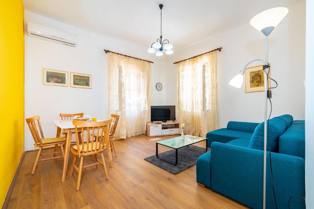 salon z niebieską kanapą i stołem w obiekcie History Apartments Center w mieście Zadar