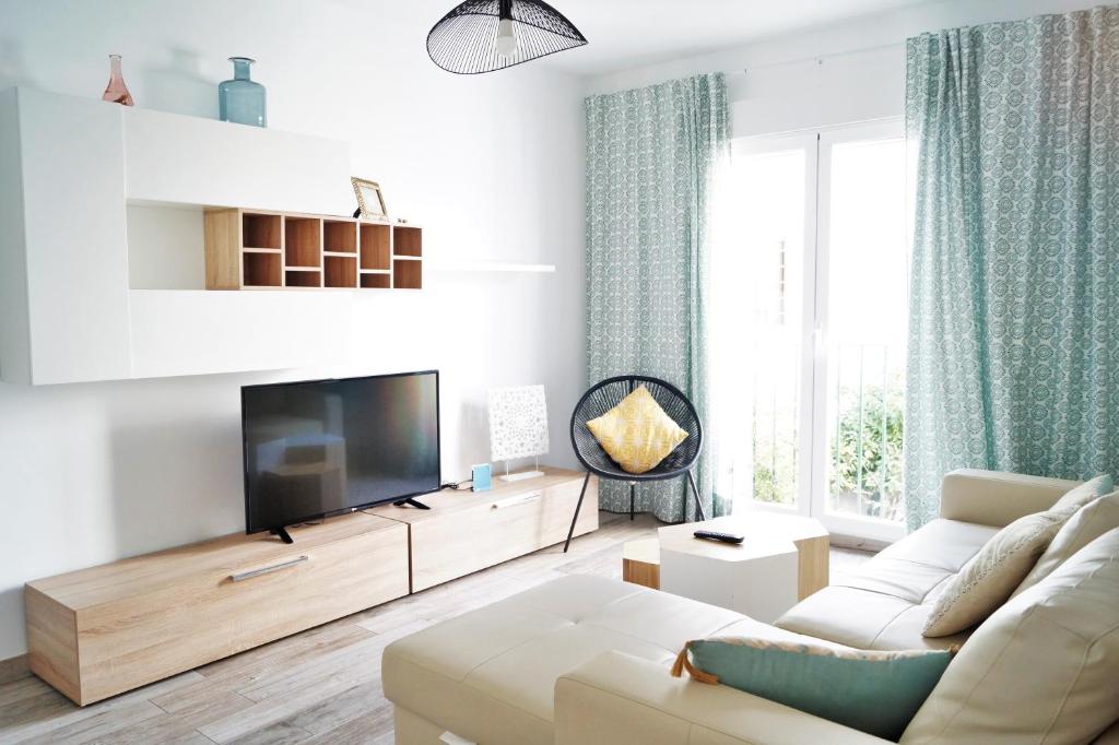 sala de estar con sofá blanco y TV de pantalla plana en Apartamento Mihrab, excelente ubicacion en casco historico, en Córdoba