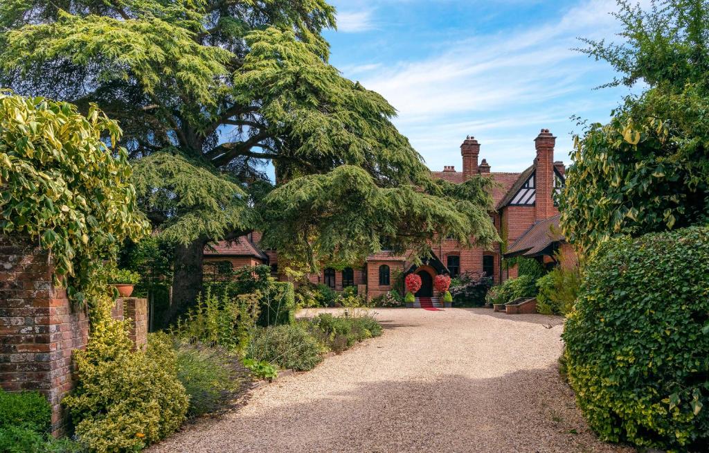 una entrada que conduce a una casa con un árbol en Careys Manor Hotel & SenSpa en Brockenhurst