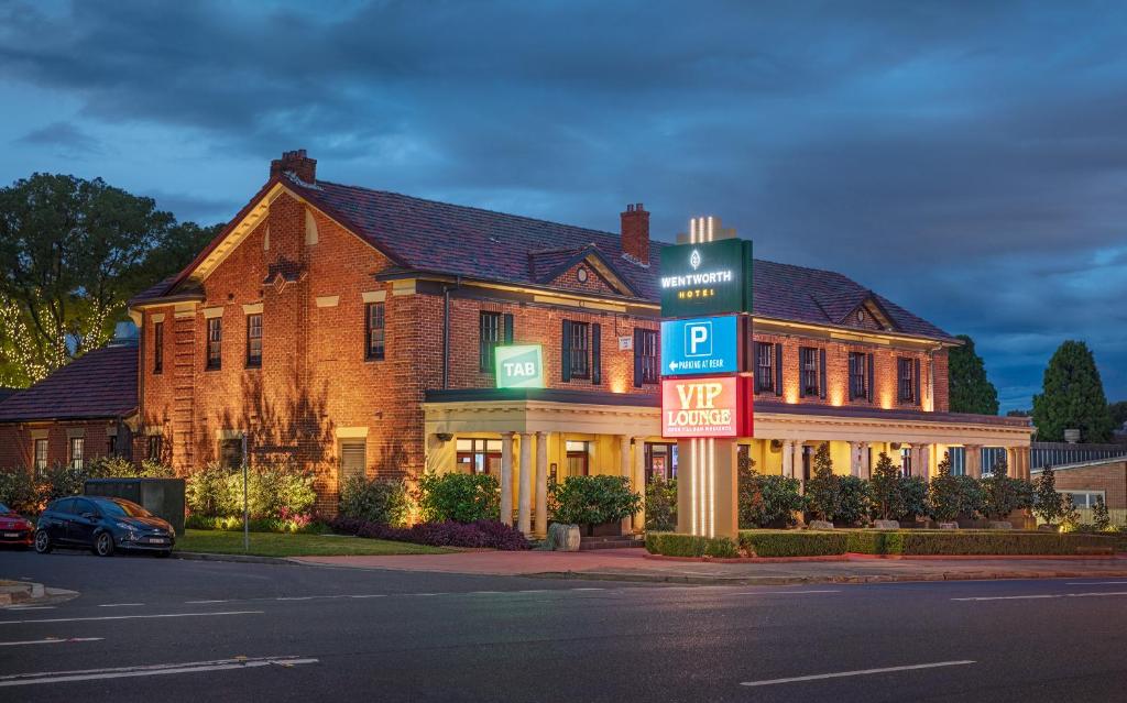 um grande edifício de tijolos com uma placa em frente em Wentworth Hotel em Sidney